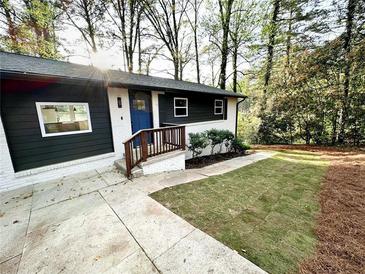 Charming home with a freshly painted exterior, manicured lawn, and a bright blue front door at 2371 Cresta Dr, Decatur, GA 30032