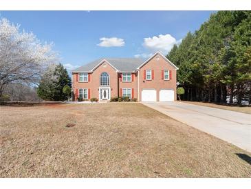 Charming two-story brick home with red shutters and attached two-car garage on a large lot at 6844 Cavalier Ct, Stone Mountain, GA 30087