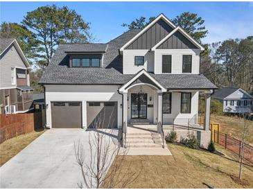 Charming two-story home featuring a symmetrical design, three-car garage and a well-manicured front lawn at 1857 Defoor Ave, Atlanta, GA 30318