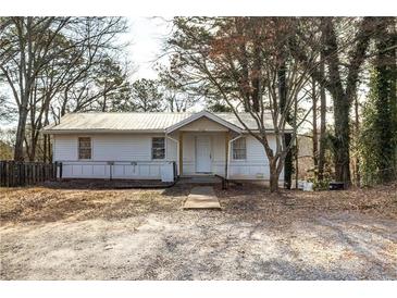 Charming home featuring a white exterior, a metal roof, and a simple entryway surrounded by mature trees at 251 Killian St, Canton, GA 30114