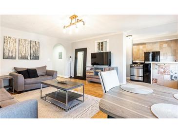 Cozy living room featuring a modern light fixture, hardwood floors, and comfortable seating area at 300 W Peachtree St # 10D, Atlanta, GA 30308