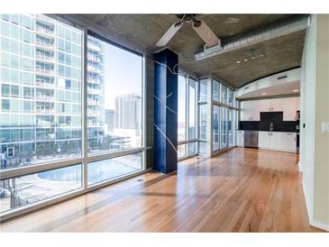 Bright living room with floor-to-ceiling windows and a view of the city and the kitchen at 923 Peachtree Ne St # 932, Atlanta, GA 30309