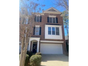 A brick two-story townhouse featuring a large two-car garage and classic architectural details at 572 Vinings Estates Se Dr # B9, Mableton, GA 30126
