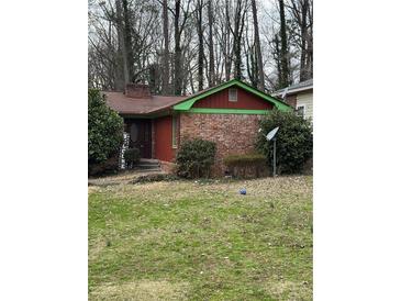 Charming one-story home with a brick facade and inviting front yard with mature trees at 2765 Rollingwood Se Ln, Atlanta, GA 30316