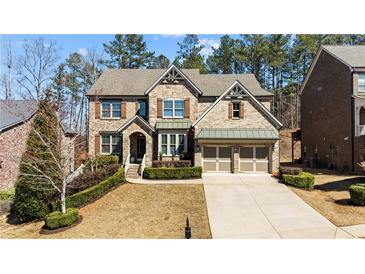 Charming brick two-story home with manicured landscaping, and a two-car garage at 2820 Garonne Way, Cumming, GA 30041