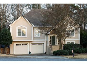 Charming two-story home with a well-manicured lawn, two-car garage, and lush landscaping at 2325 Woodcrest Se Dr, Smyrna, GA 30082