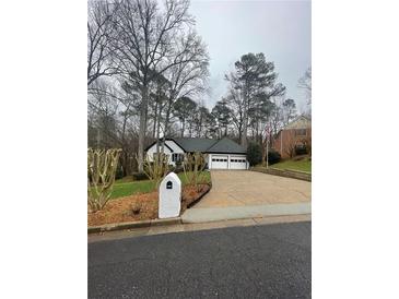 Charming one-story home with a three-car garage and well-maintained front yard at 1190 Saint Ives Ct, Suwanee, GA 30024