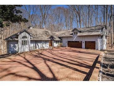 Stunning home featuring a large brick driveway and attached two-car garage at 6575 Roundhill Ct, Cumming, GA 30040