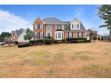 Charming two-story brick home with a well-manicured front lawn and mature landscaping at 5292 Candleberry Sw Dr, Lilburn, GA 30047