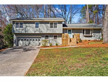Charming split-level home featuring a garage, a welcoming front yard, and a light-blue painted front door at 5403 Woodberry Cir, Marietta, GA 30068