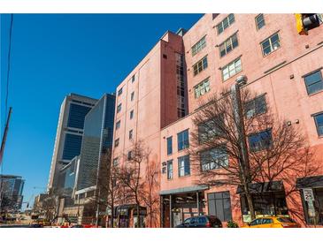 Condo building exterior with a brick facade, lots of windows, and a clear blue sky above at 87 Peachtree Sw St # 204, Atlanta, GA 30303