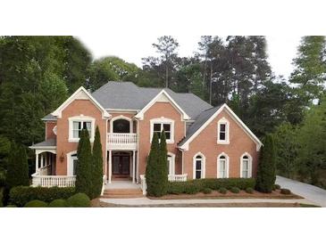 Stately brick home with a symmetrical facade, Juliet balcony, manicured landscaping, and elegant architectural details at 2650 Riverfront Dr, Snellville, GA 30039