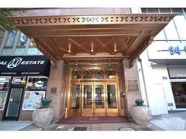 The William Oliver building entrance with gold canopy, gold doors, and planters on either side of the doorway at 32 Peachtree Nw St # 202, Atlanta, GA 30303