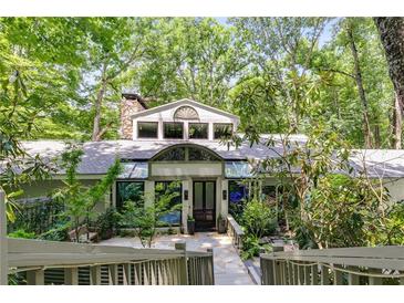 Beautiful home exterior with stone accents, mature trees, and unique architectural details at 385 Grimes Bridge Rd, Roswell, GA 30075