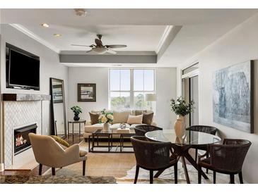 Inviting living room featuring a fireplace, ceiling fan, and lots of natural light at 2881 Peachtree Ne Rd # 702, Atlanta, GA 30305