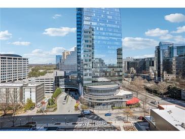 Modern glass high-rise building with rounded corner detail in a city setting against a blue sky at 3324 Peachtree Ne Rd # 1115, Atlanta, GA 30326