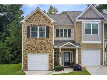 Charming townhome showcasing brick facade, front lawn and attached single-car garage at 10166 Benton Woods Dr, Covington, GA 30014