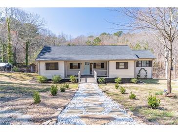 Charming home featuring a welcoming front porch, tidy landscaping, and a stone walkway leading to the entrance at 3465 Callie Still Rd, Lawrenceville, GA 30045