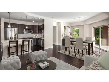 Open living space featuring kitchen with stainless steel appliances and dining area with access to the balcony at 200 River Vista Dr # 205, Atlanta, GA 30339