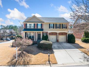 Two-story home with brick and tan siding, well-manicured lawn, and a two-car garage at 4790 Maristone Landing Way, Cumming, GA 30040
