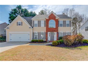 Charming two-story home with a brick accent, manicured lawn, and attached two-car garage at 1042 Wildwood Wake Bnd, Dacula, GA 30019