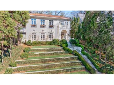 Elegant home with manicured tiered landscaping and a staircase leading to the front entrance at 388 Beverly Ne Rd, Atlanta, GA 30309