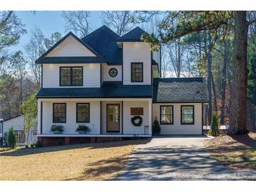 Charming two-story home with white siding, black trim, and a well-manicured lawn, offering classic curb appeal at 8404 Majors Rd, Cumming, GA 30041