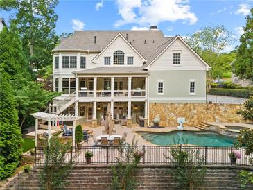 Stunning backyard with a stone patio, in-ground pool, outdoor kitchen, and beautiful landscaping at 2480 Flint Creek Dr, Cumming, GA 30041