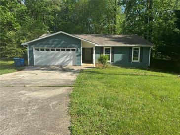 Charming single-story home featuring an attached garage and a well-maintained lawn at 815 Oxford Hall Dr, Lawrenceville, GA 30044