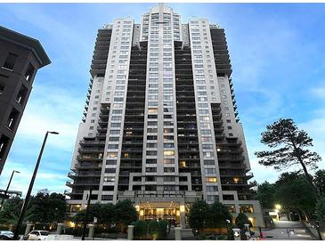 Exterior view of a modern high-rise condo building featuring balconies, trees, and manicured landscaping at 3481 Lakeside Ne Dr # 1705, Atlanta, GA 30326
