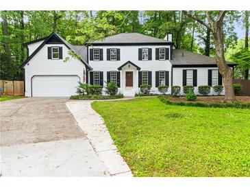 Charming two-story home with a two car garage and front lawn at 3900 Millwood Lane Nw, Lilburn, GA 30047