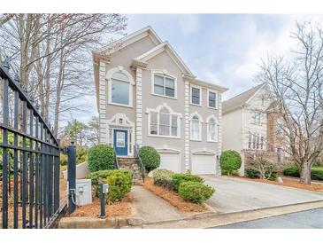 Charming two-story home featuring detailed architectural trim, arched windows, attached garage, and well-maintained landscaping at 2426 Vivian Cir, Decatur, GA 30030