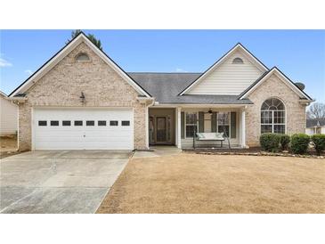 Charming brick home featuring a two-car garage and inviting front porch swing at 4037 Mcpherson Dr, Acworth, GA 30101