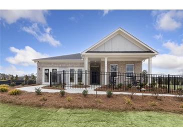 Charming brick home featuring a covered front porch, manicured lawn, and decorative fencing, offering a welcoming curb appeal at 147 Park Lane Ln, Fairburn, GA 30213