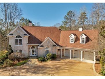 Charming two-story brick home with a three-car carport and well-maintained landscaping at 3460 Mansions Pkwy, Berkeley Lake, GA 30096