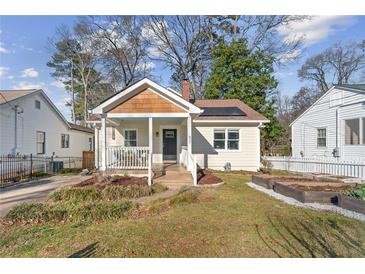 Charming bungalow with a welcoming front porch, solar panels, and landscaped garden beds at 633 Mckoy St, Decatur, GA 30030