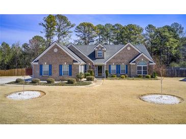 Charming brick home with blue shutters, manicured lawn, and mature trees at 1832 Millstone Mnr, Conyers, GA 30013