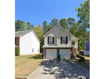 Inviting two-story home featuring a two-car garage, neutral siding, and lush landscaping at 3954 Riverside Pkwy, Decatur, GA 30034