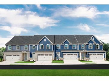 Charming blue townhomes with white garage doors and brick accents under a cloudy sky at , Mcdonough, GA 30253