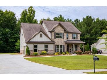 Inviting two-story home featuring a manicured lawn, brick accents and a covered porch at 200 Bexley Pkwy, Tyrone, GA 30290