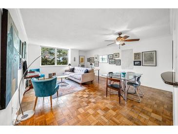 Bright living room featuring hardwood floors, a ceiling fan, comfortable seating, and a dining area at 2965 Pharr Court South Nw # 712, Atlanta, GA 30305