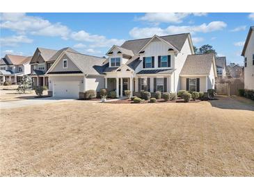 Charming two-story home with a manicured front yard, attached garage, and classic architectural details at 2207 Derbyshire Sw Dr, Marietta, GA 30064