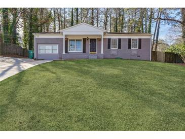 Charming single-story brick home with a manicured lawn and inviting front porch in a wooded neighborhood at 2350 Brenda Se Dr, Smyrna, GA 30080