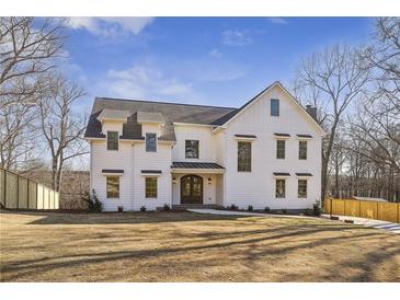 Beautiful two-story modern farmhouse featuring a large front yard and dark shingle roof at 510 Forest St, Buford, GA 30518
