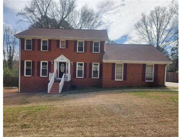 Charming two-story brick home with a well-manicured lawn and classic red shutters, offering timeless curb appeal at 956 S Deshon Rd, Lithonia, GA 30058