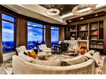Expansive living room with floor-to-ceiling windows, a grand piano, and custom built-in bookshelves with a fireplace at 3376 Peachtree Ne Rd # 56, Atlanta, GA 30326