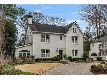 Charming two-story white brick home featuring classic architecture and a beautifully landscaped front yard at 80 26Th Nw St, Atlanta, GA 30309