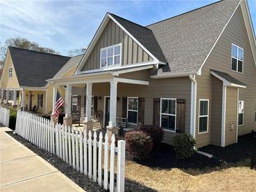 Charming home features a covered porch, white picket fence, and beautifully landscaped front yard at 207 Tan Yard Rd, Social Circle, GA 30025