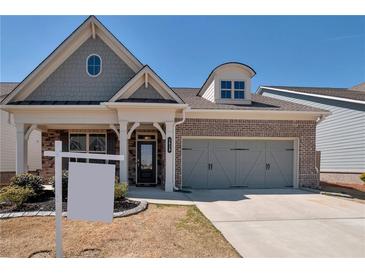 Charming home featuring a brick facade, two-car garage, and a well-manicured lawn at 2628 Songbird Ln, Grayson, GA 30017