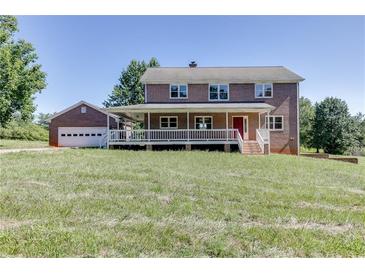 Charming two-story brick home featuring a welcoming front porch and a detached garage at 4840 Pisgah Rd, Cumming, GA 30028